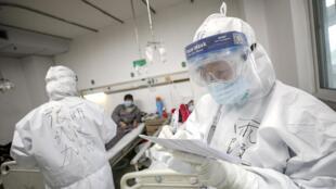 A medical worker in protective suit checks a patient's records at Jinyintan hospital in Wuhan, the epicentre of the novel coronavirus outbreak, in Hubei province, China February 13, 2020. Picture taken February 13, 2020.