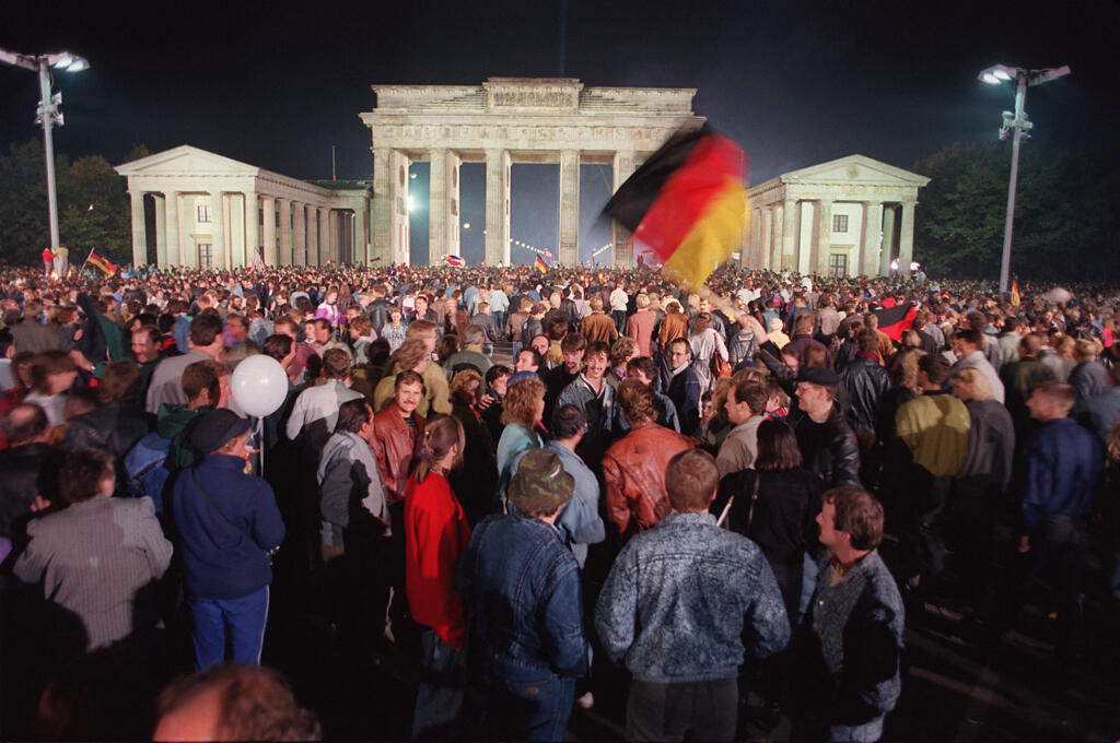 Rassemblement de jeunes Berlinois pour célébrer  la réunification du pays à la Porte de Brandebourg, à Berlin, le 3 octobre 1990.