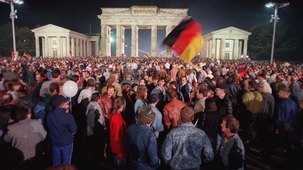 Rassemblement de jeunes Berlinois pour célébrer  la réunification du pays à la Porte de Brandebourg, à Berlin, le 3 octobre 1990.