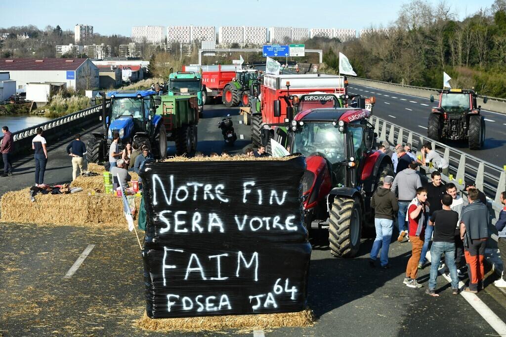 "Nosso fim será a sua fome", diz cartaz estendido por agricultores na estrada A63, perto da cidade de Bayonne, no sudoeste francês. (23/01/2024)