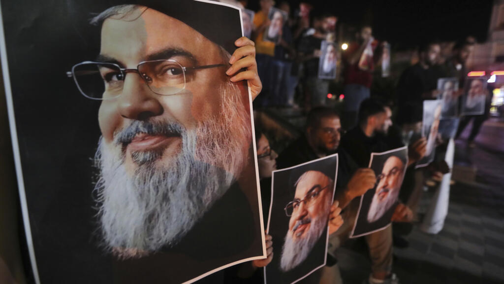 Des Libanais et des Palestiniens tiennent le portrait d'Hassan Nasrallah lors d'une manifestation pour protester contre son assassinat, le 28 septembre 2024 à Sidon, dans le sud du Liban.