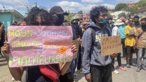 A protester holds a placard during a demonstration against repeated water and electricity outages in Antananarivo on 27 September 2025.