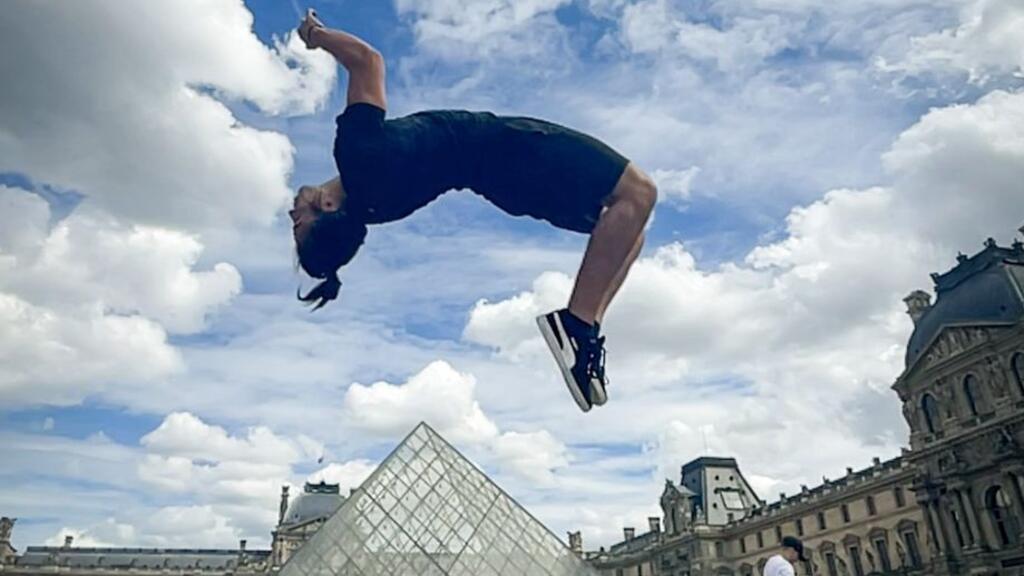 O brasileiro Gustavo D'Artagnan Sousa realiza um salto diante do Museu do Louvre, em Paris.