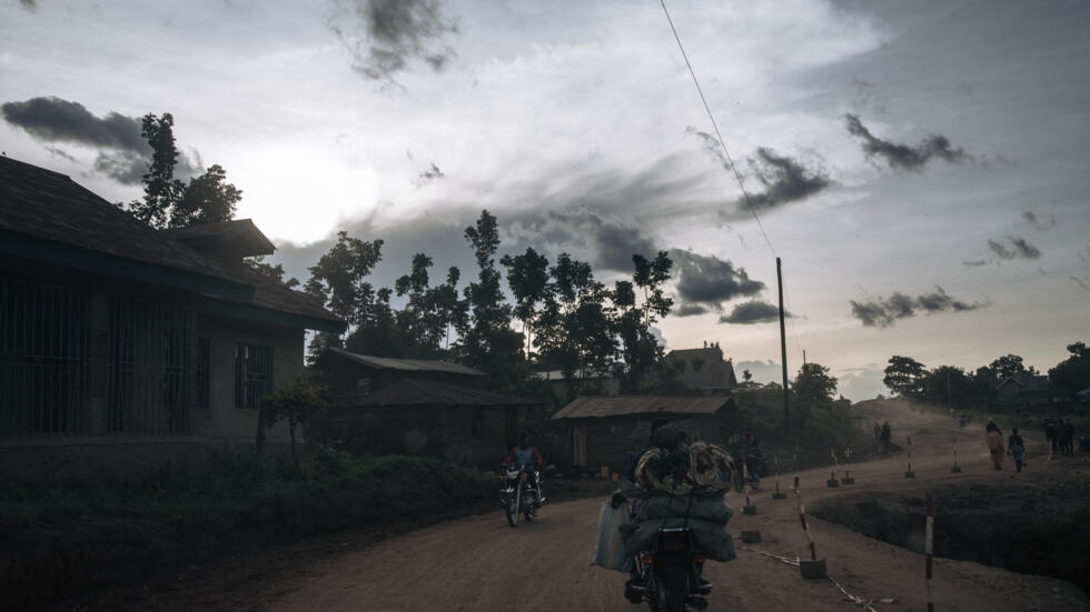 Waendesha pikipiki wanaosafiri kwenye barabara ya Beni-Kasindi, ambapo ADF, kundi la waasi kutoka Uganda, linaendesha harakati zake mashariki mwa DRC, Mei 9, 2024 katika eneo la Beni, Kivu Kaskazini , mashariki mwa Jamhuri ya Kidemokrasia ya Kongo.