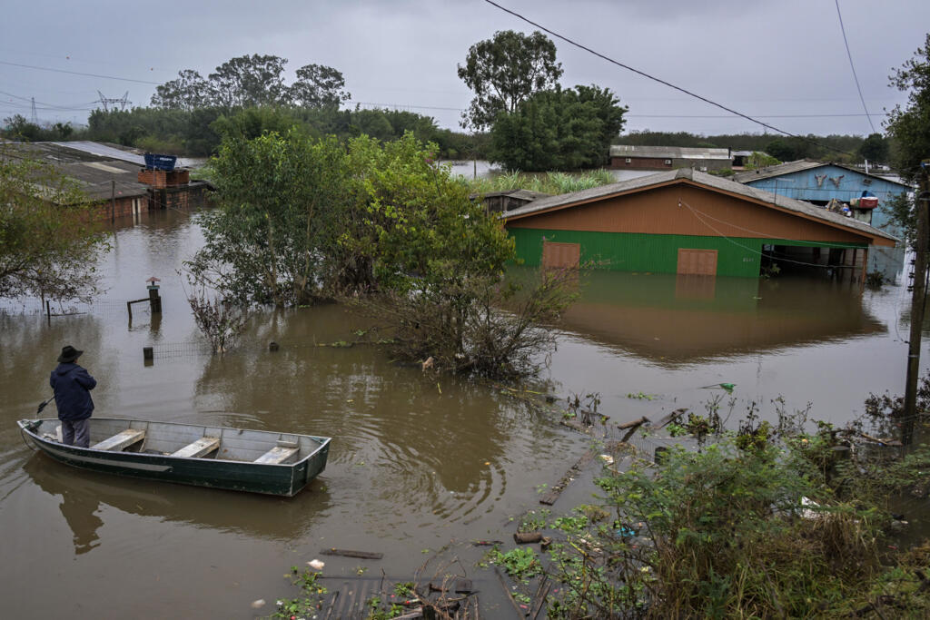 Um homem em um barco em frente a casa inundada em Canoas, no sul do Brasil, em 13 de maio de 2024.