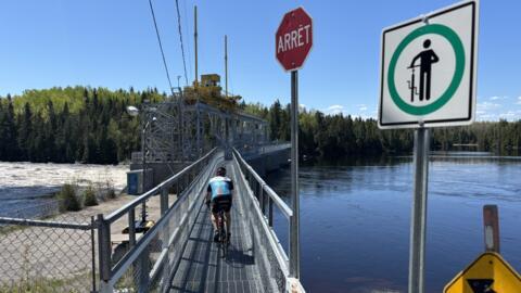 Un cycliste sur un barrage de la Véloroute des Bleuets, au Canada.