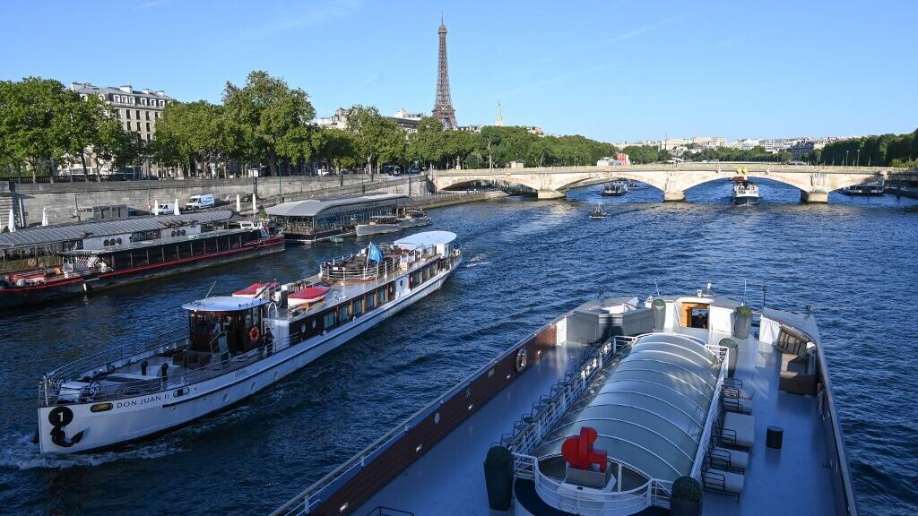 Barcos navegam em direção à Torre Eiffel, no rio Sena, em 17 de julho de 2023, durante a fase de testes das manobras, distâncias, duração e captura de vídeo da cerimônia de abertura dos Jogos Olímpicos Paris-2024.