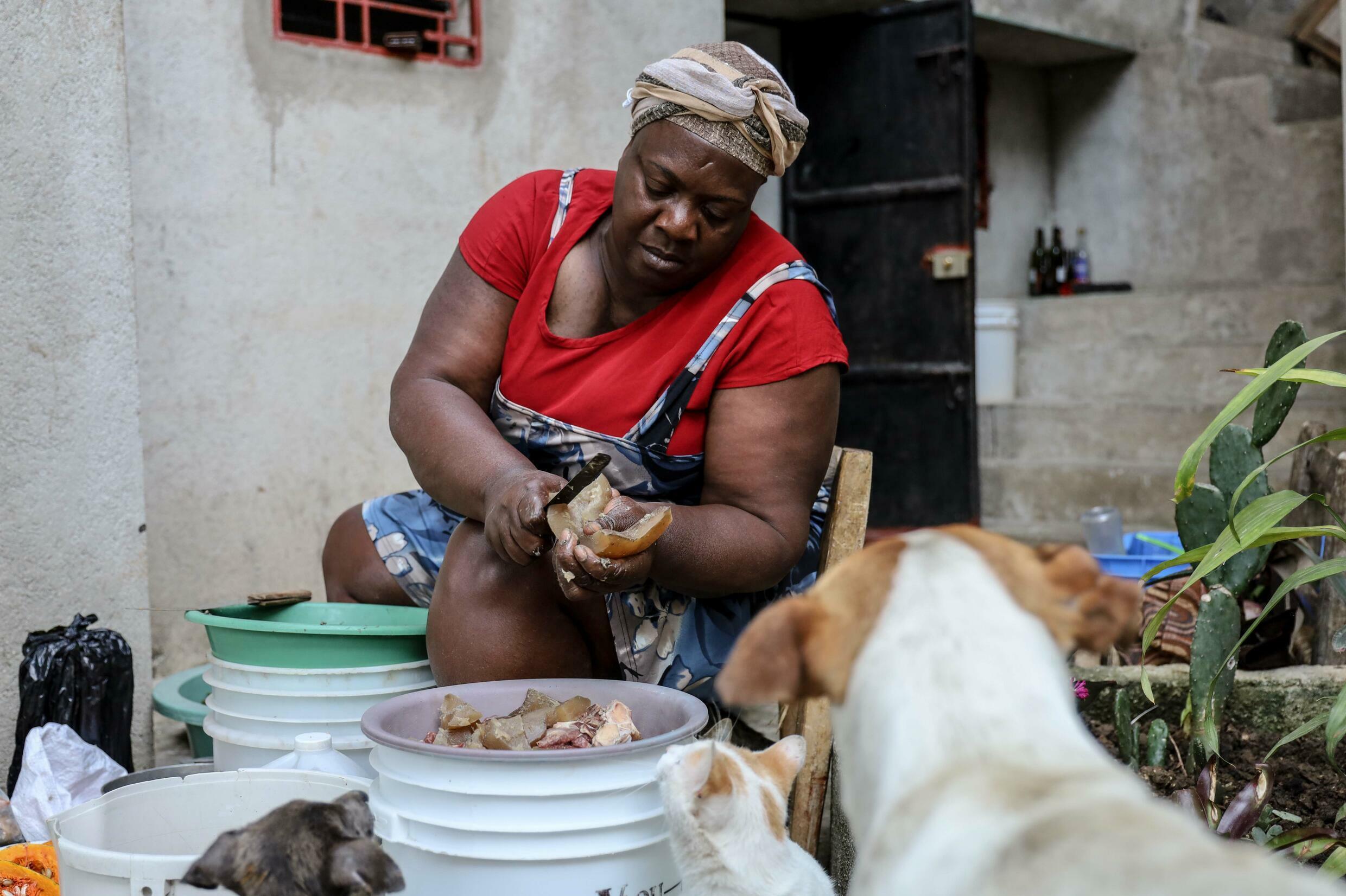 Rosmin d'Orseus prepares a traditional soup, on December 31, 2021 in Port-au-Prince, Haiti