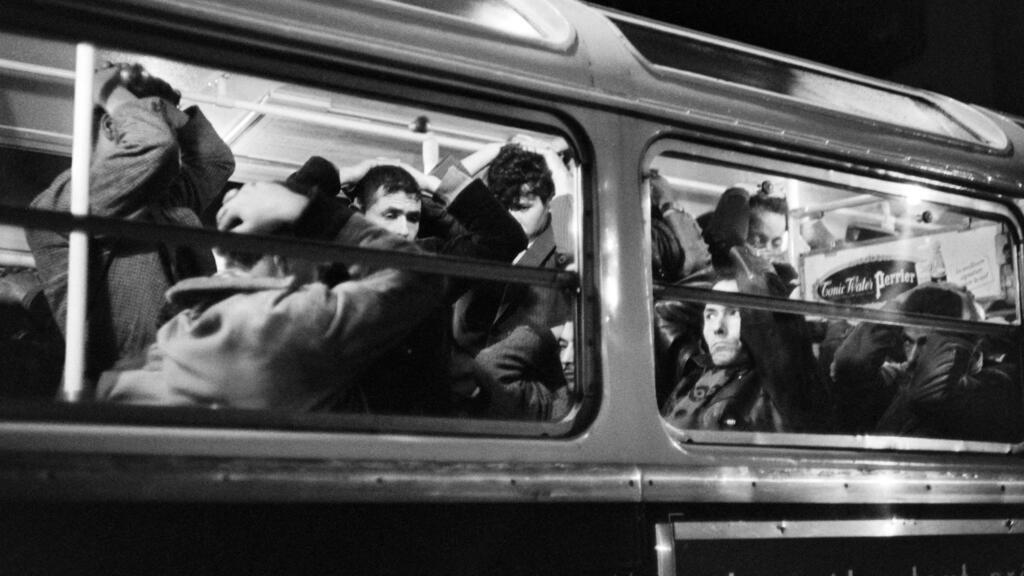 es manifestants algériens arrêtés lors de la manifestation pacifique du 17 octobre 1961 attendent les mains au-dessus de la tête dans un bus réquisitionné par la police.