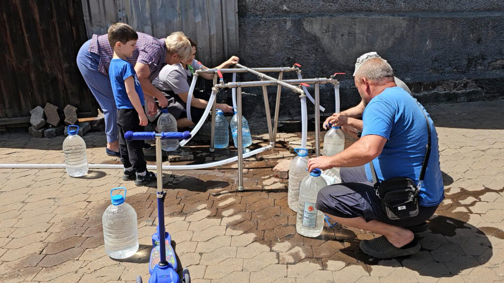 Des habitants de Novohrodivka viennent chercher de l'eau à un puits de fortune.