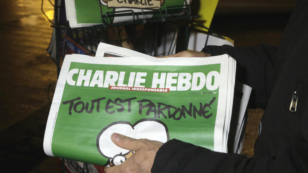 Dans cette photo d'archive du mercredi 14 janvier 2015, un vendeur de journaux stocke plusieurs journaux de Charlie Hebdo dans un kiosque à journaux à Nice, en France.