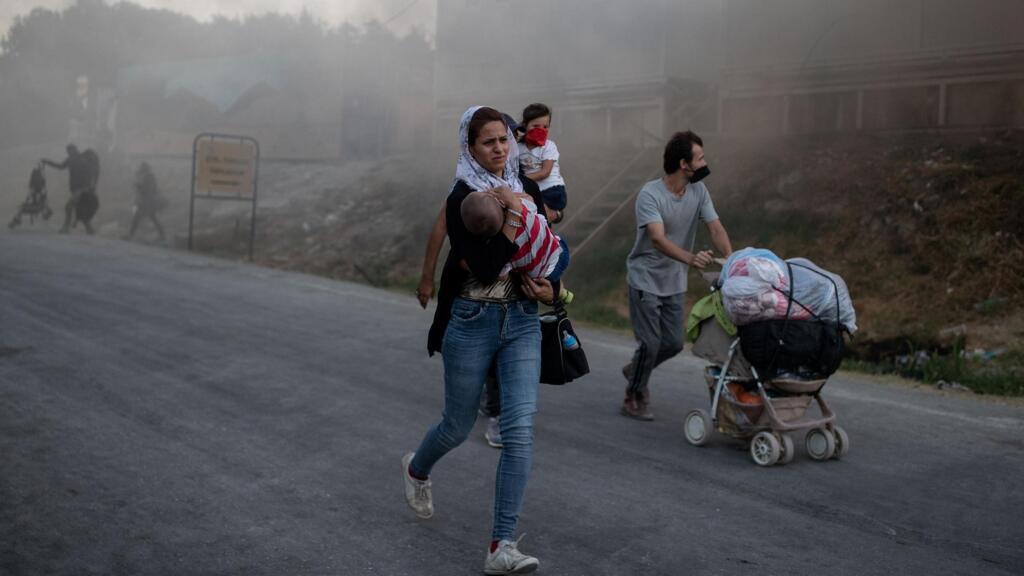 Une famille fuit les flammes lors de l'incendie du camp de Moria sur l'île de Lesbos, le 9 septembre 2020.