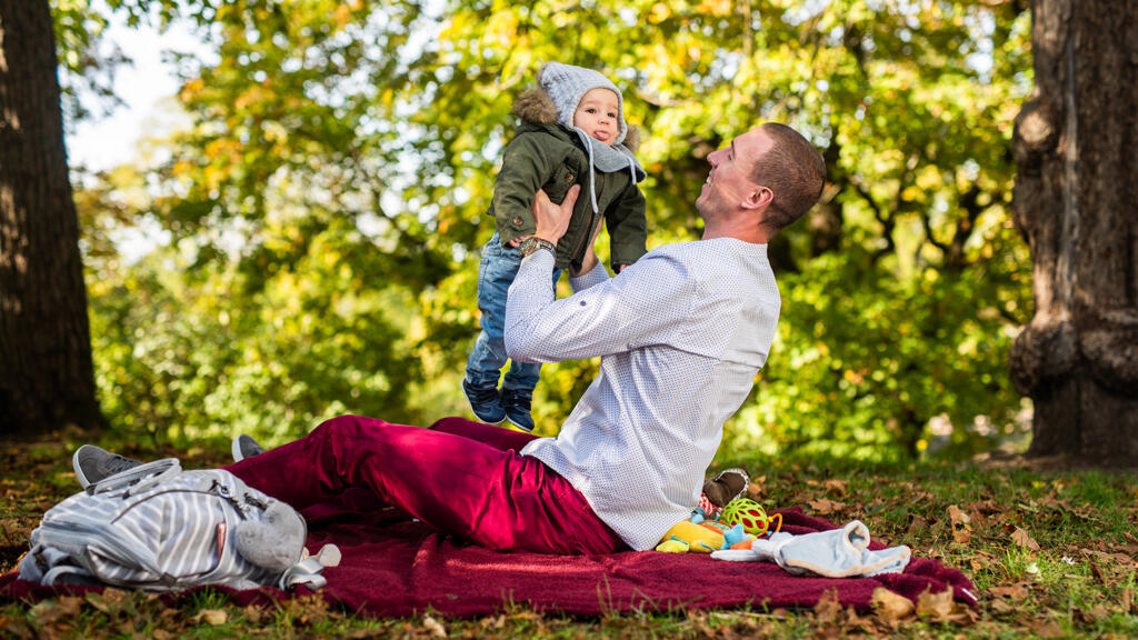 Un bébé joyeux et son papa dans un parc en Norvège.