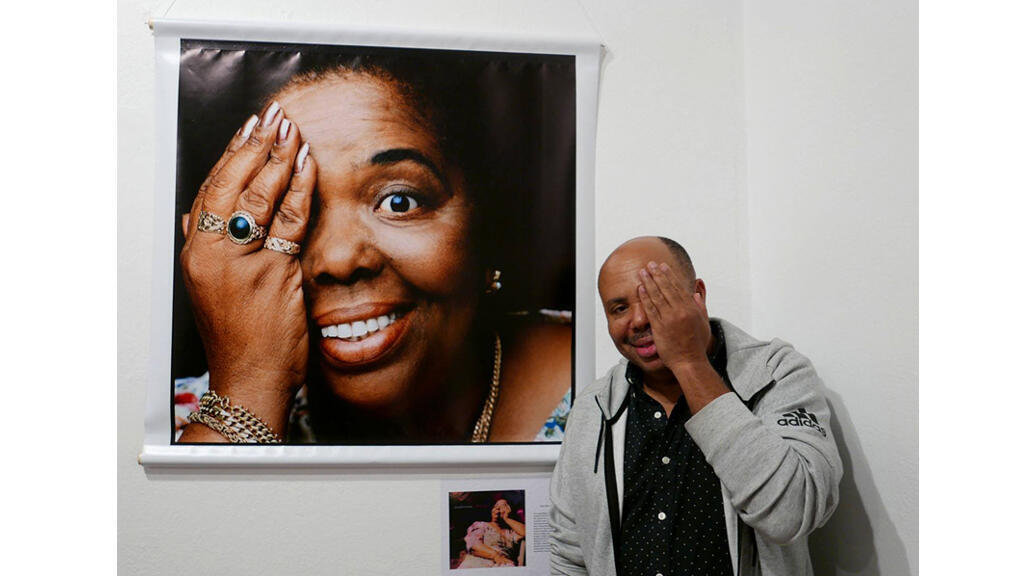 José da Silva, posant devant une photo de Césaria Evora, immortalisée par Youri Lenquette, Maputo mai 2018.