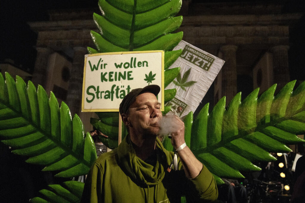 Um homem dá uma tragada em um cigarro de maconha em frente ao Portão de Brandemburgo durante o evento 'Smoke-In' em Berlim, Alemanha, em 1º de abril de 2024.