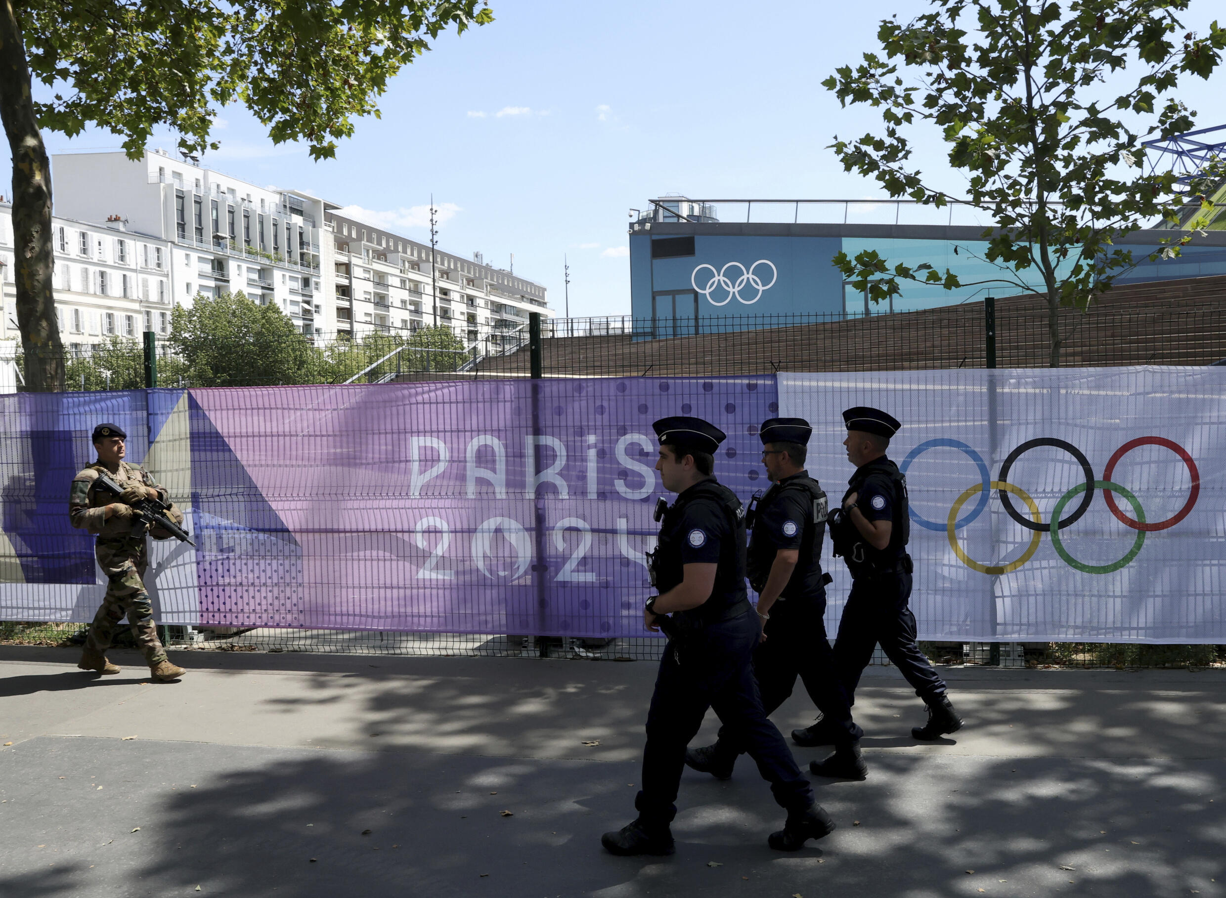 Un militaire et des policiers patrouillent avant le début des Jeux olympiques de Paris, en France, le 17 juillet 2024.