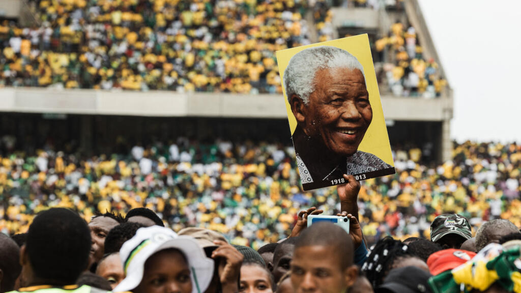 Les partisans de l'ANC, photo de l'ancien président Nelson Mandela au-dessus de la tête, lors du lancement du manifeste électoral du parti à Durban, le 24 février 2024.