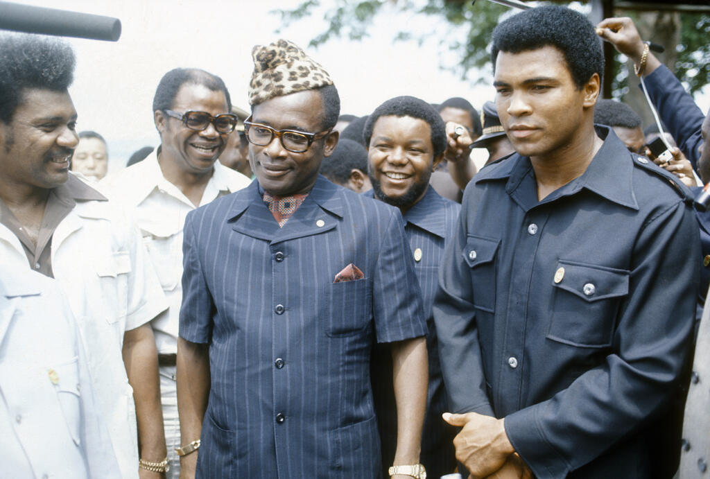 Le boxeur poids lourd Mohamed Ali (d) Mobutu Sese Seko (c) et Don King, promoteur de boxe professionnelle américain, (g) avant le combat de boxe entre Ali et George Forman, programmé le 30 octobre 1974 en République du Zaïre.
