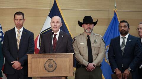 Le gouverneur de l'Utah, Spencer Cox (au c.) lors d'une conférence de presse, à Orem, dans l'Utah, le 12 septembre 2025.
