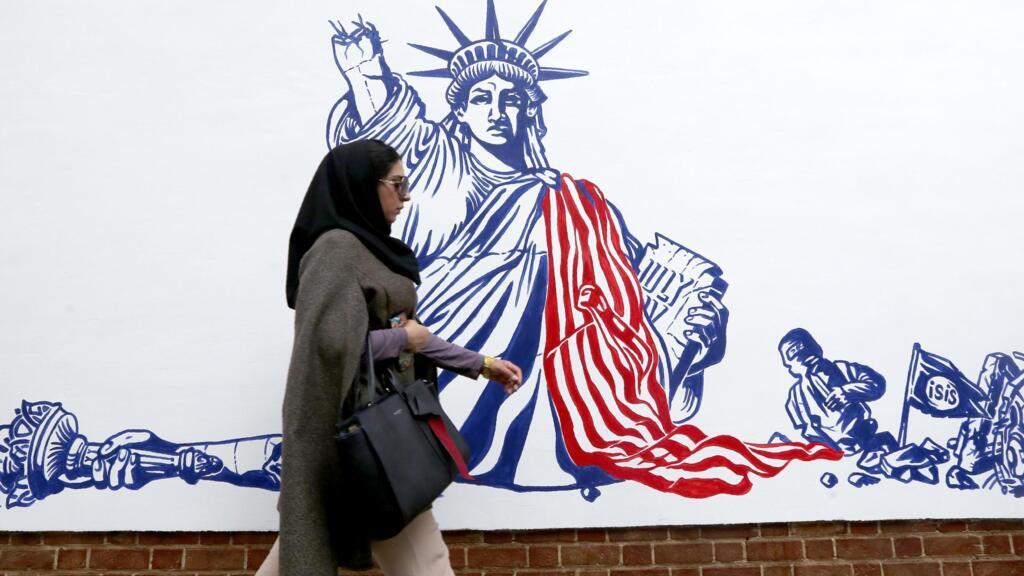 Une Iranienne passe devant l'une des fresques antiaméricaines inaugurées devant l'ancienne ambassade américaine de Téhéran, le 2 novembre 2019.