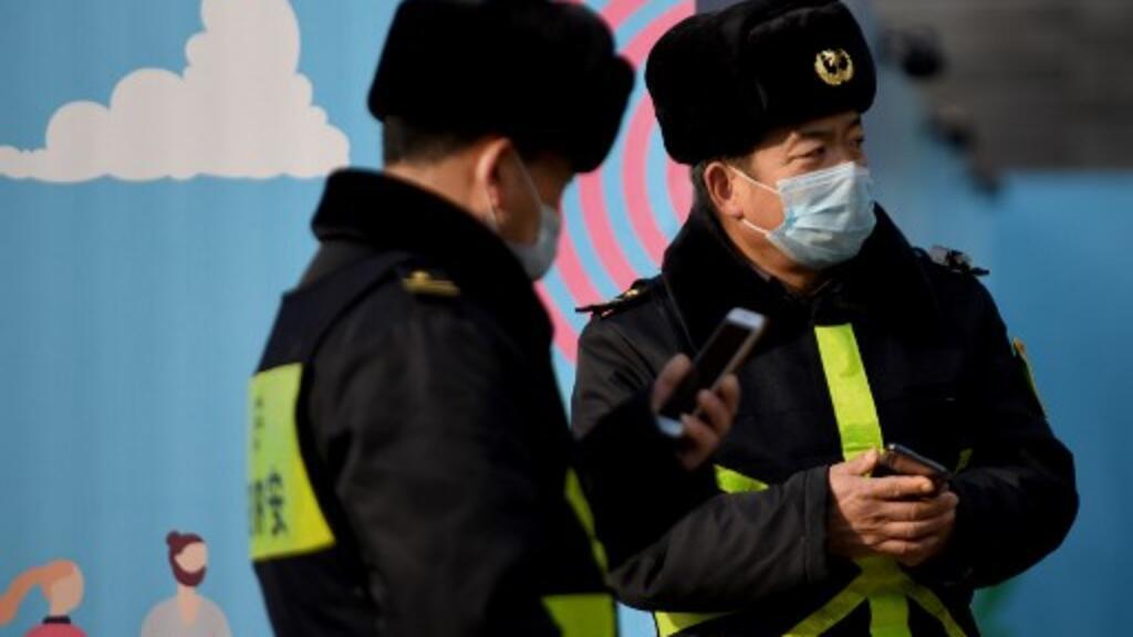 Des officiers de police portant un masque à Pékin. La Cité interdite de Pékin a annoncé sa fermeture pour éviter tout risque de contamination entre les visiteurs, et les festivités du Nouvel An lunaire ont été annulées dans la capitale chinoise.