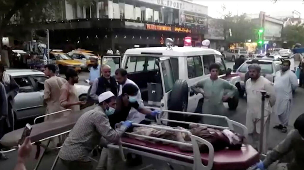 Une capture d'écran montre des personnes transportant une personne blessée vers un hôpital après un double attentat à l'aéroport de Kaboul en Afghanistan, le 26 août 2021.