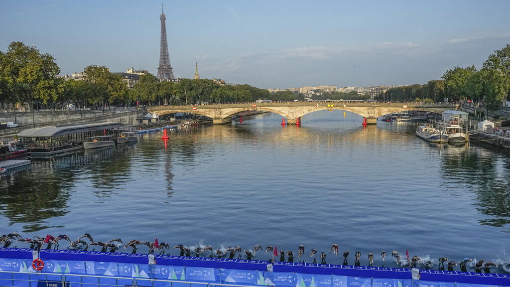 Atletas mergulham no rio Sena a partir da ponte Alexandre III, no início da primeira etapa do evento-teste de triatlo feminino para os Jogos Olímpicos de Paris 2024. Em Paris, em 17 de agosto de 2023. Em 2024, a ponte será o cenário para a linha de chegada das provas individuais de ciclismo, maratona de natação, triatlo e para-triatlo.