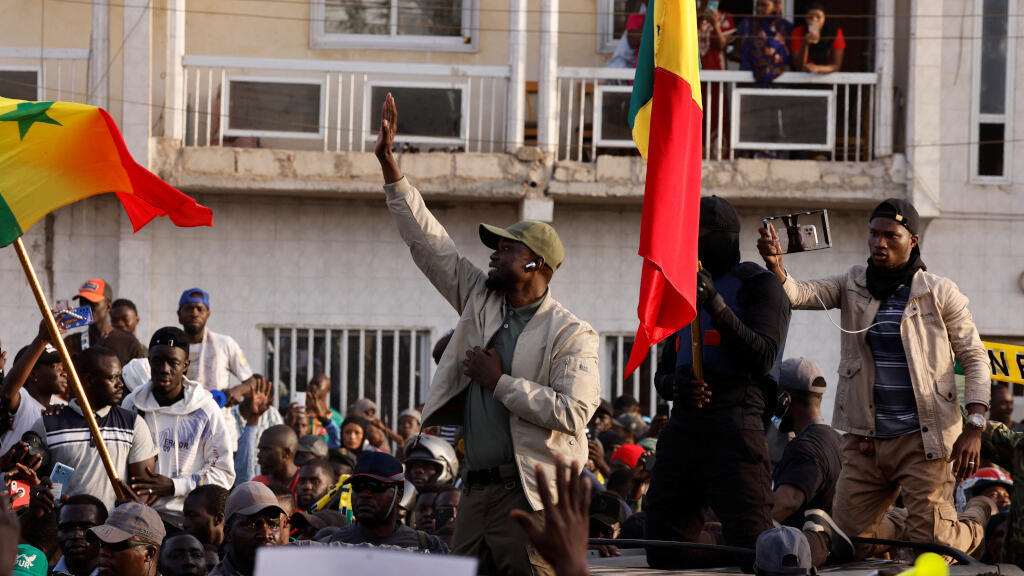 Le chef de l'opposition sénégalaise Ousmane Sonko salue ses partisans alors qu'il arrive pour assister à la manifestation pour exiger la libération de prisonniers politiques présumés avant sa comparution devant le tribunal jeudi pour diffamation, à Dakar, Sénégal, le 14 mars 2023.