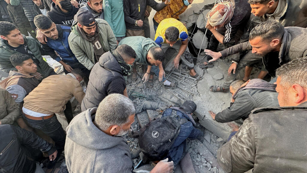 Des Palestiniens fouillent les décombres d'une mosquée détruite par des frappes israéliennes à Rafah, le 24 janvier 2024.