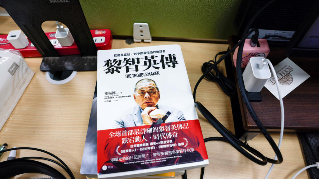 2025年12月15日,在台湾台北,一本关于传媒大亨、苹果日报创始人黎智英的书籍摆放在前苹果日报记者的办公桌上。路透社/Ann Wang