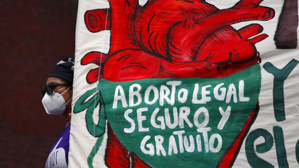Mulher segura uma faixa em espanhol, "Aborto legal, seguro e livre", durante uma manifestação sobre direitos ao aborto diante do Congresso Nacional no "Dia da Descriminalização do Aborto na América Latina e no Caribe", na Cidade do México. 28/05/2020