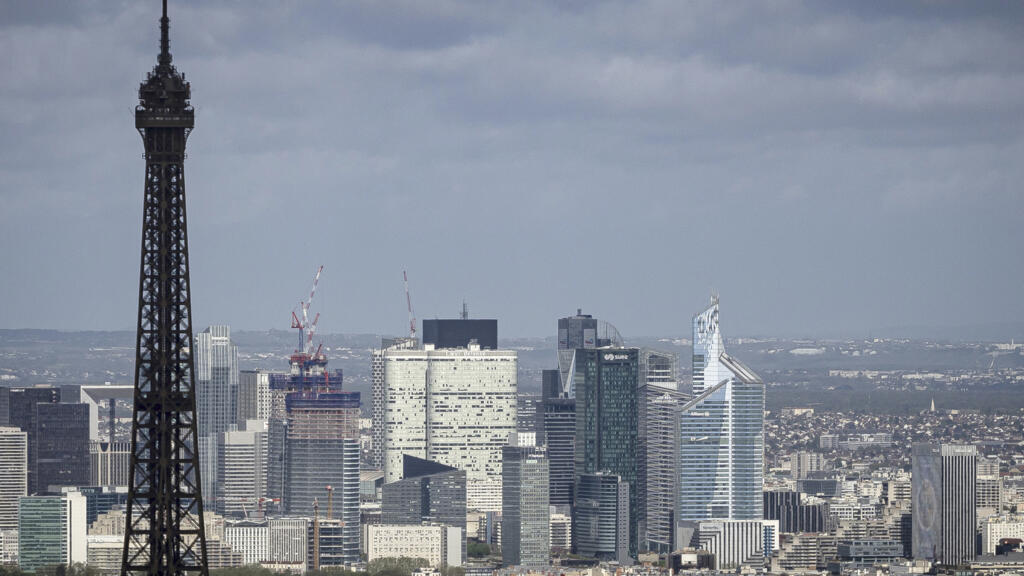 Torre Eiffel e ao fundo o bairro La Défense, nos arredores de Paris, onde se concentram as sedes de grandes empresas francesas.