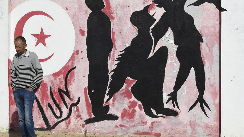 Un homme devant des graffitis sur la place Mohamed Bouazizi, au centre de Sidi Bouzid en Tunisie, le 27 octobre 2020.