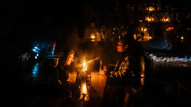 Des habitants de Kiev réunis aux chandelles dans un bar du centre de la capitale, pendant une panne d'électricité après des frappes contre l'infrastructure électrique ce vendredi 16 décembre 2022.