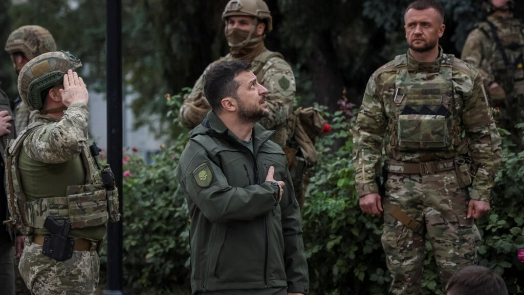 Le président ukrainien Volodymyr Zelensky chante l'hymne national lors de sa visite dans la ville récemment libérée  d'Izioum, le 14 septembre 2022. 