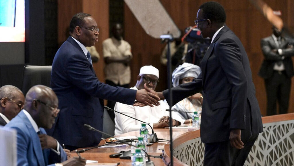 Le président sénégalais Macky Sall (Centre G) serre la main de son Premier ministre Amadou Ba (D), candidat de la majorité lors du dialogue national à Diamniadio le 26 février 2024.