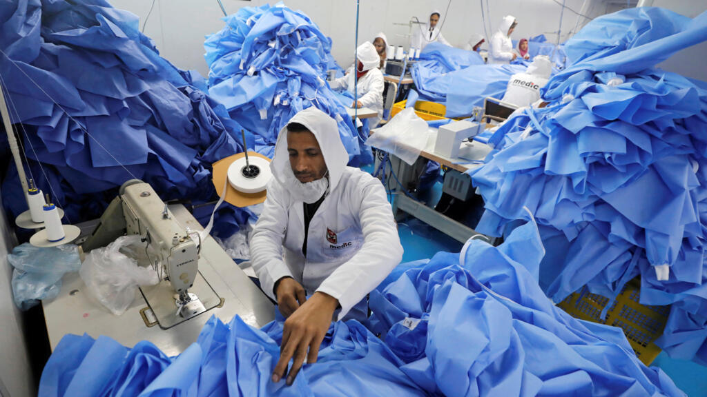 Un homme fabrique du matériel de protection chirurgical dans une usine spécialisée en Égypte, le 15 mars 2020, en pleine crise sanitaire mondiale.
