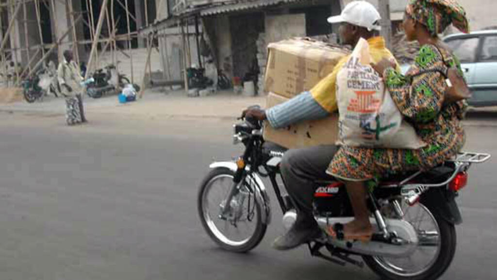 Un «zemidjan» (taxi-moto) transporte une cliente et ses bagages (photo d'illustration).