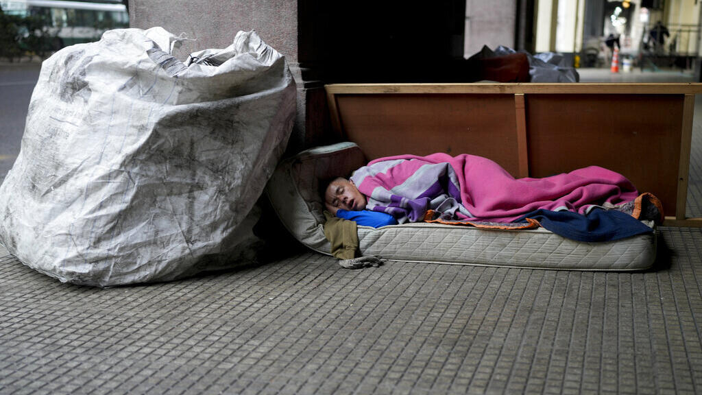 Uma pessoa sem-abrigo dorme em uma calçada em Buenos Aires, Argentina.