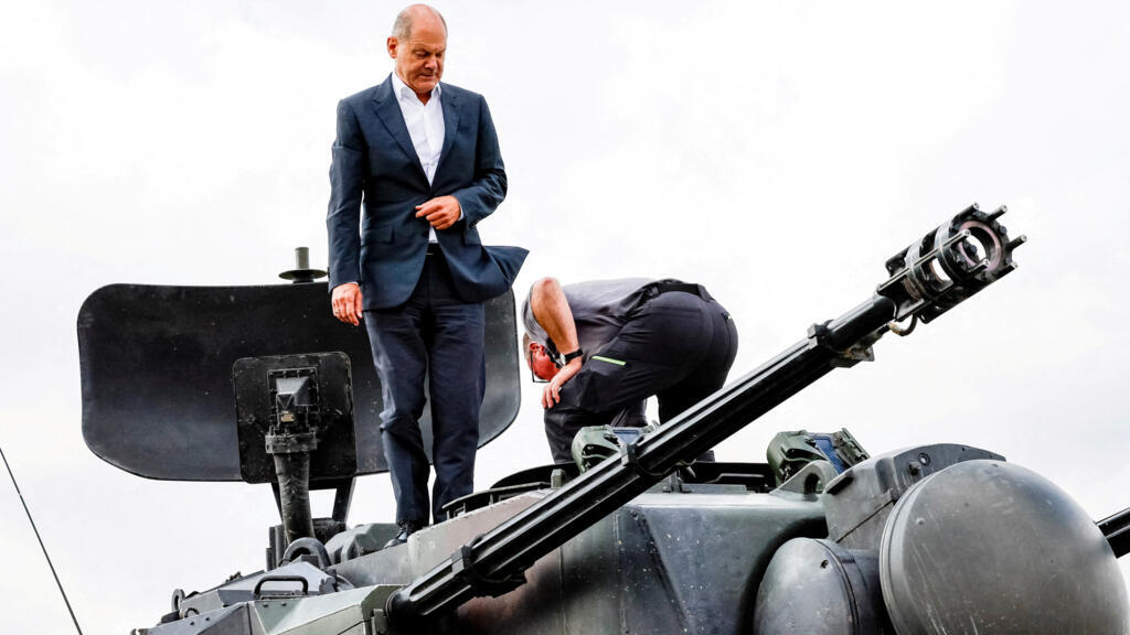 O chanceler alemão Olaf Scholz sobe em um canhão antiaéreo autopropulsado alemão Flakpanzer Gepard com o chefe de treinamento da fabricante de armas Krauss-Maffei Juergen Schoch, durante uma visita ao programa de treinamento para soldados ucranianos no tanque antiaéreo Gepard em Putlos, perto de Oldenburg, Alemanha, em 25 de agosto de 2022.