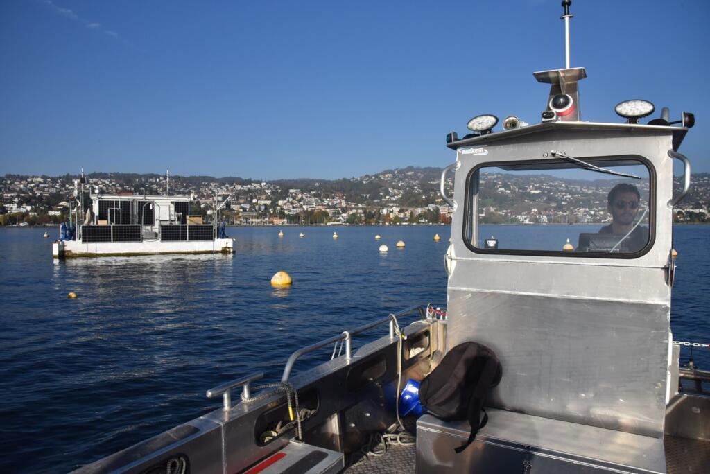 Vue des rivages suisses derrière LeXPLORE, munie de panneaux solaires pour son électricité, ainsi que d'un groupe électrogène, au cas où...