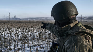 Un soldat ukrainien montre du doigt une fumée sur sa position en première ligne près de Soledar, dans la région de Donetsk, en Ukraine, ce mercredi 11 janvier 2023.