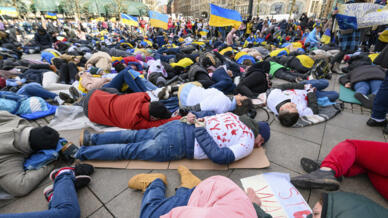 Des manifestants allongés au sol lors d'un rassemblement contre la guerre en Ukraine, à Hambourg en Allemagne, le 9 avril 2022.