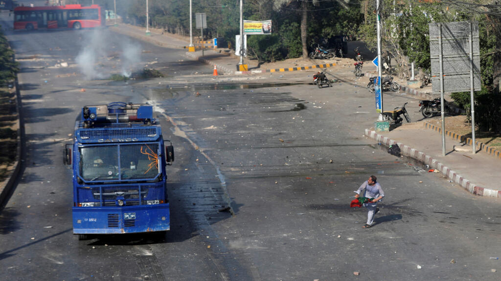 Un partisan de l'ancien Premier ministre pakistanais Imran Khan jette des pierres sur un véhicule de police lors d'une manifestation après l'arrestation de Khan, à Karachi, au Pakistan, le 9 mai 2023.