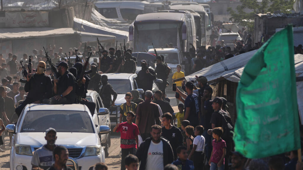 Hamas gunmen escort buses carrying freed Palestinian prisoners arriving in the Gaza Strip after their release from Israeli jails under a ceasefire agreement between Hamas and Israel, in Khan Younis, s