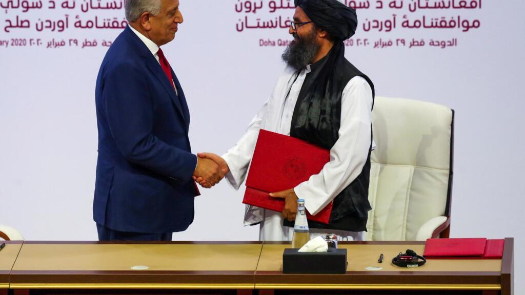 Le mollah Abdul Ghani Baradar, chef de la délégation talibane, et Zalmay Khalilzad, envoyé américain pour la paix en Afghanistan, se serrent la main après avoir signé un accord à Doha, le 29 février2020.