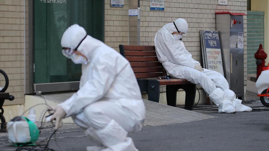 Des membres du personnel médical attendent les ambulances qui transportent des malades contaminés par le coronavirus Covid-19, à l'entrée de l'hôpital de Daegu, le 23 février 2020.