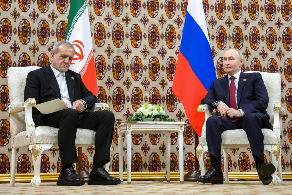Iranian President Masoud Pezeshkian, left, and Russian President Vladimir Putin during the talks on the sidelines of an international forum in Ashgabat, Turkmenistan, Friday, Dec. 12, 2025. (Alexander