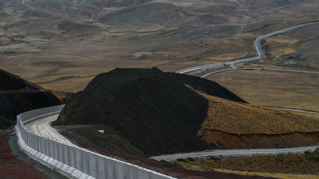A concrete wall, topped with barbed wire and surrounded by trenches, is being erected along Turkey's border with Iran