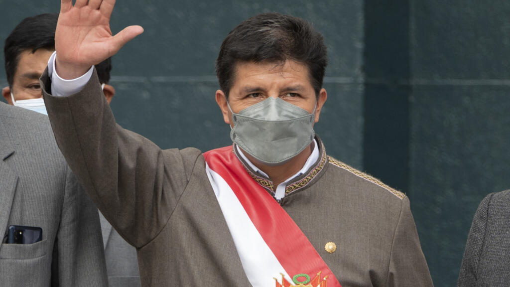 O presidente peruano Pedro Castillo acena ao deixar o edifício do Congresso em Lima em 28 de março de 2022, após uma breve declaração na câmara onde ele reinvindicou direito de ser representado por um advogado durante uma discussão para um possível impeachment.